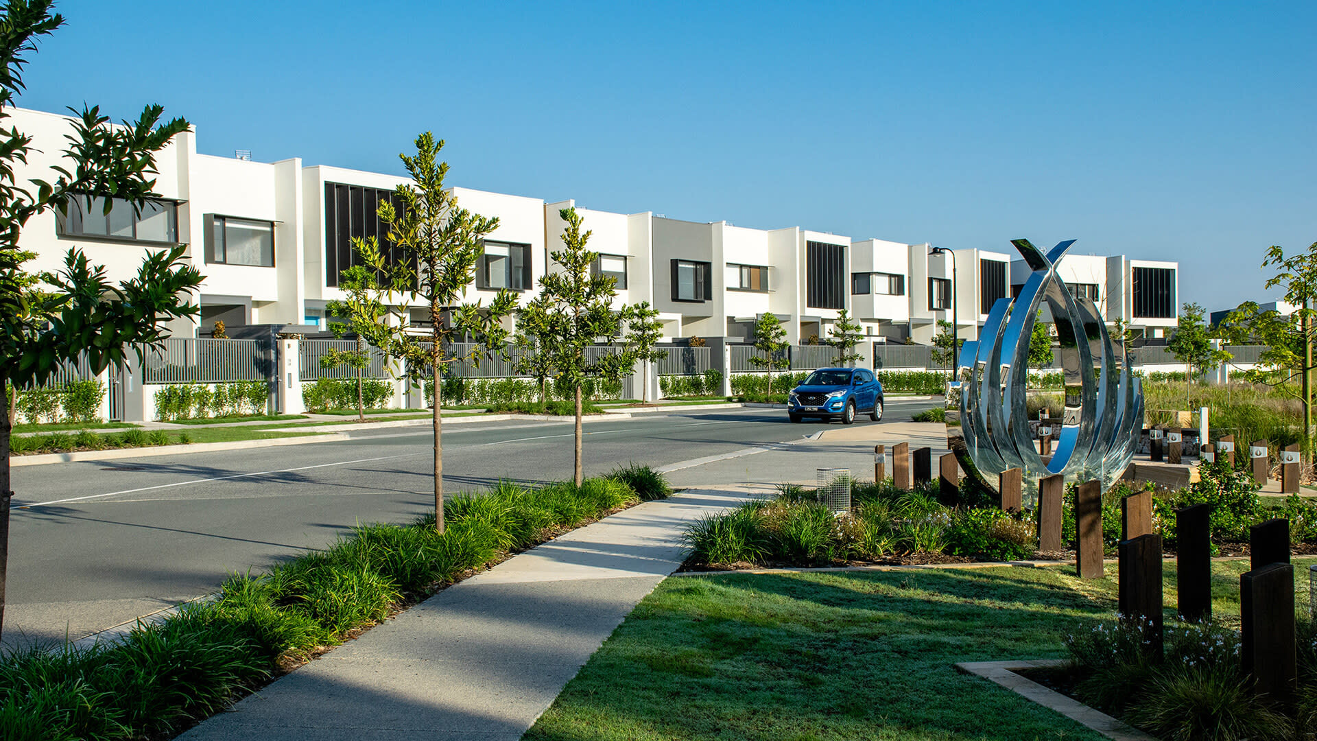 A modern housing estate with a lotus shaped statue at the front.