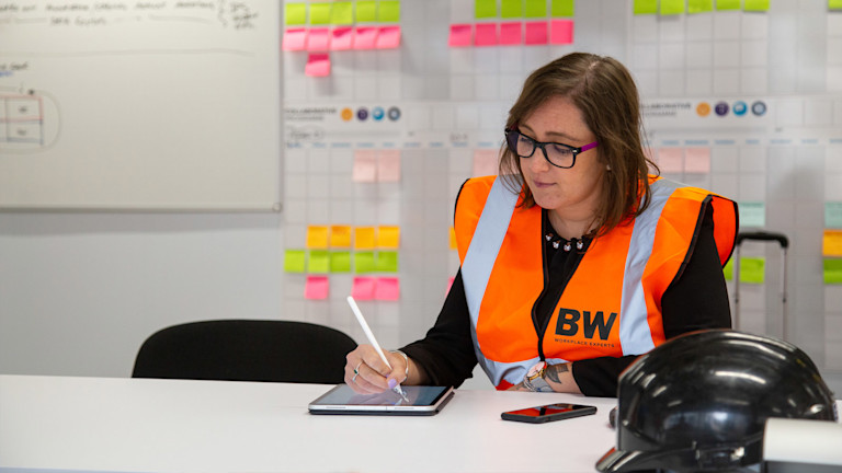 Customer in an office making updates to documents on an iPad with a touch pen