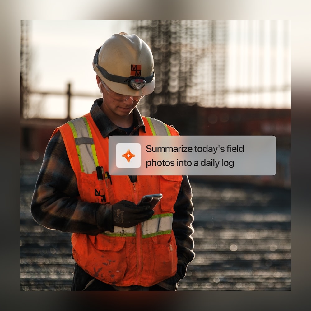Construction worker in safety gear using smartphone on job site