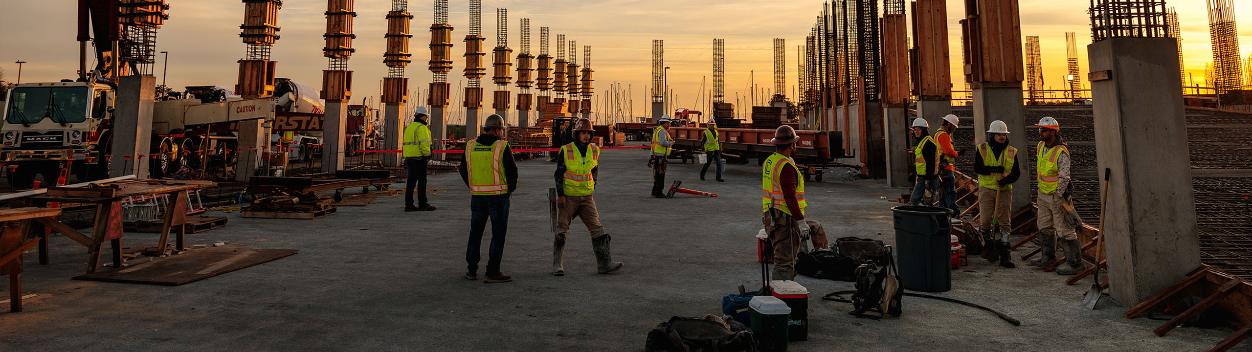 Construction workers standing in a rooftop of an unfinished building