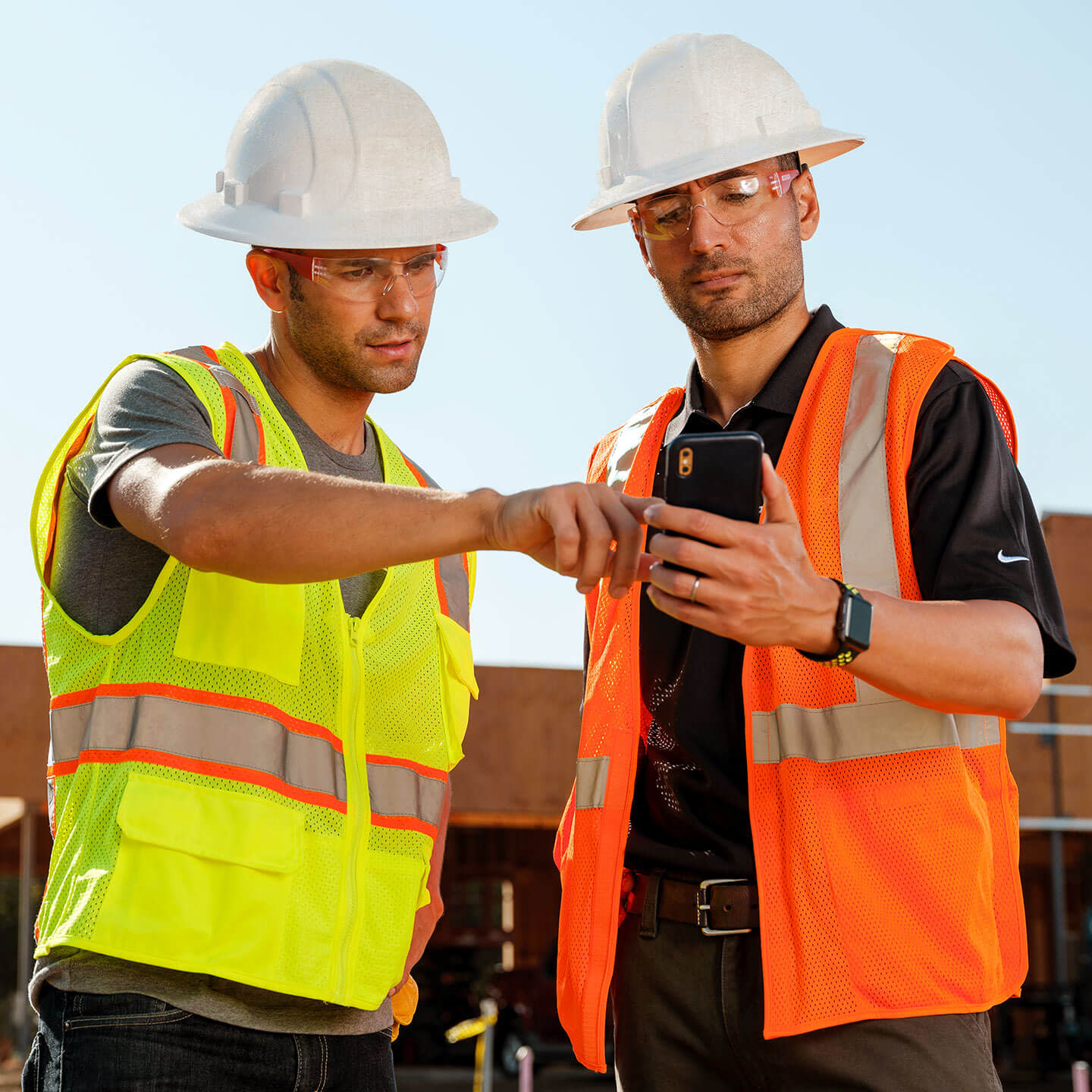 Construction workers looking at mobile device