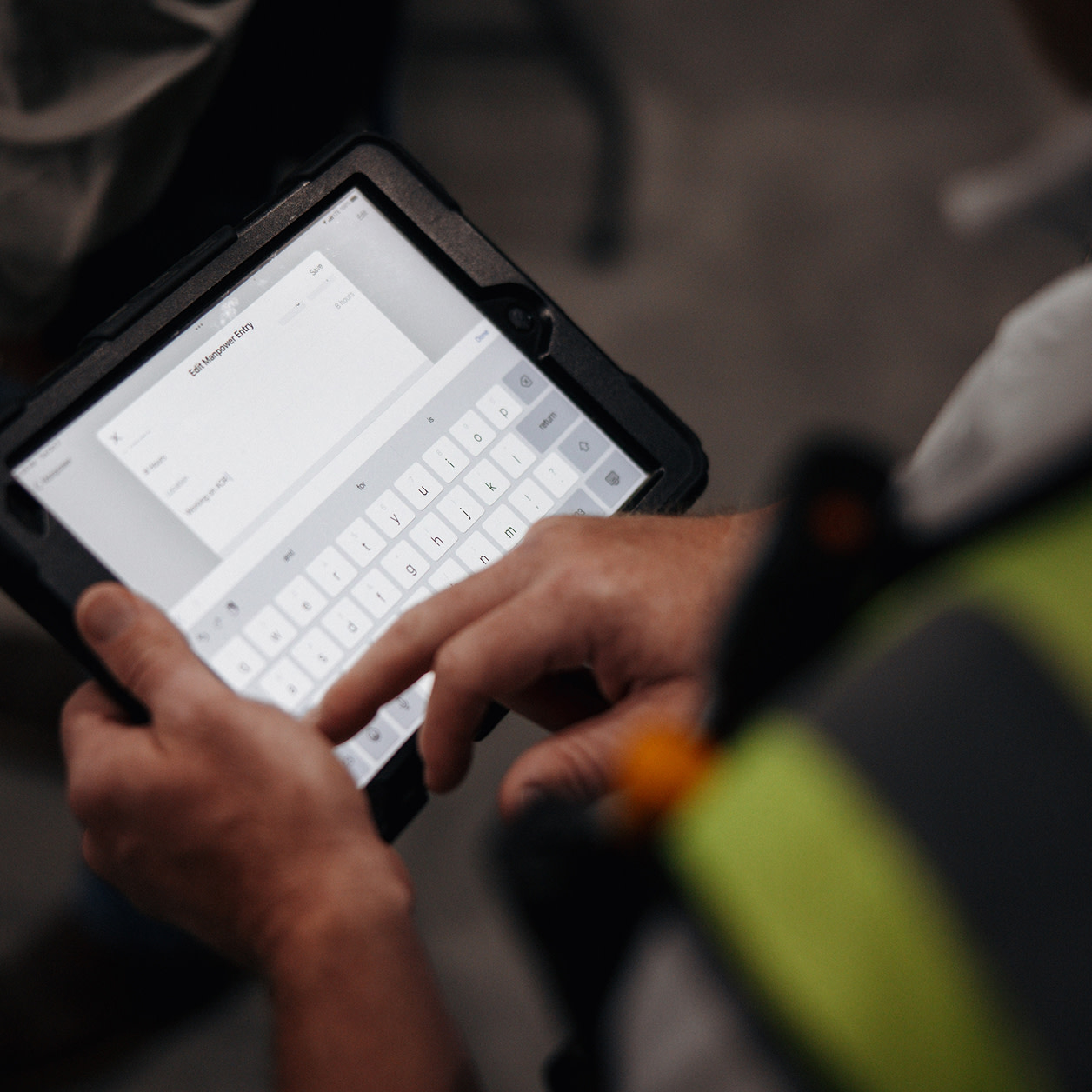 Close up of a person using Procore on a tablet
