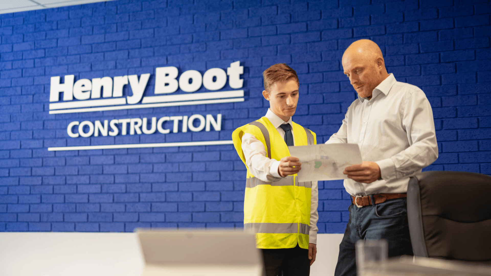 Two men on Henry Boot offices looking at a blueprint