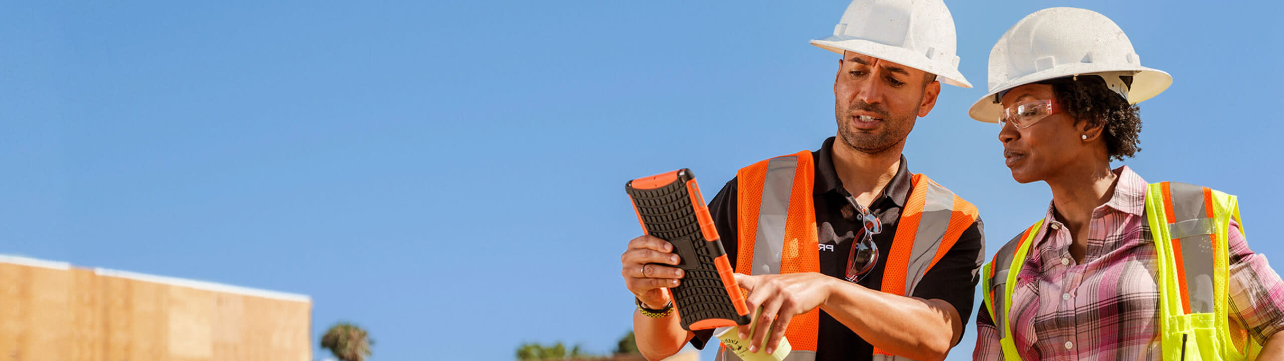 Construction workers using Procore on an iPad on a jobsite