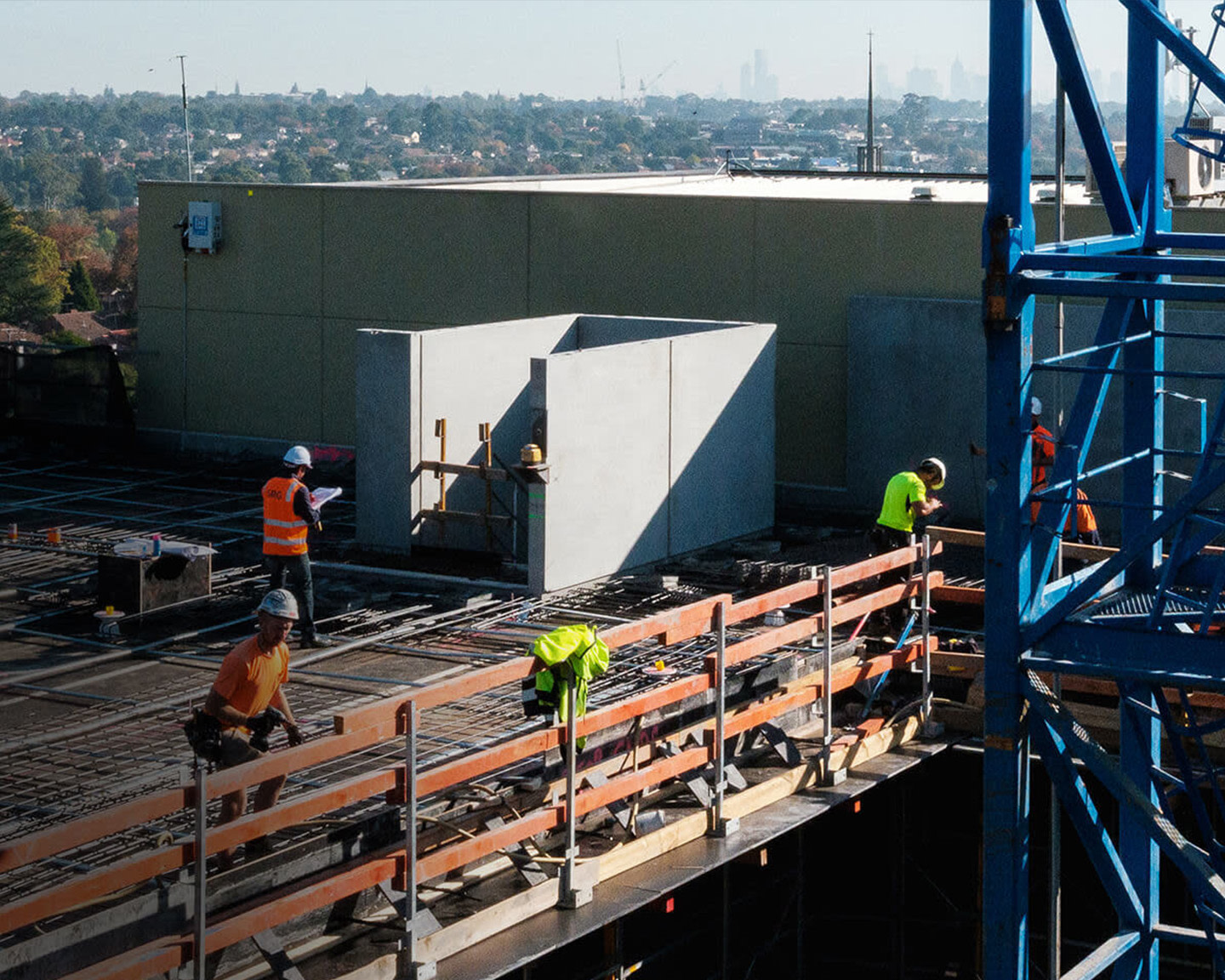 Construction workers working on a rooftop under construction