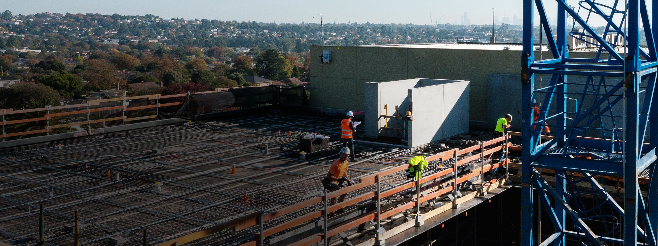 Construction workers working on a rooftop under construction