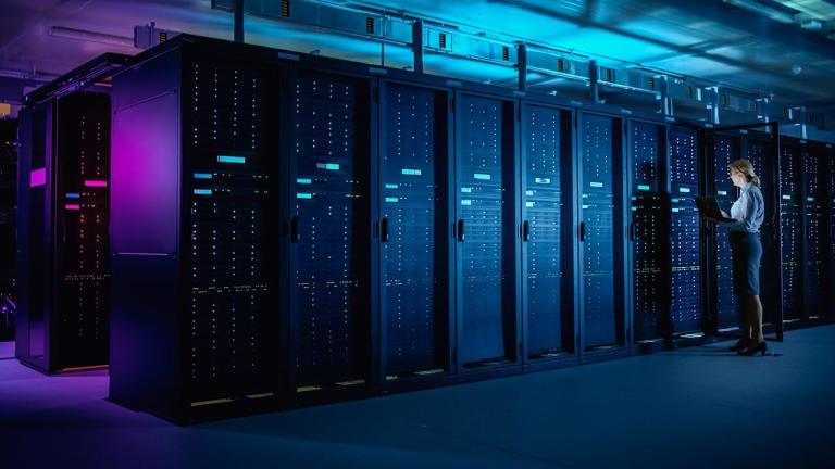 Interior of a Data Center with a worker checking server stacks