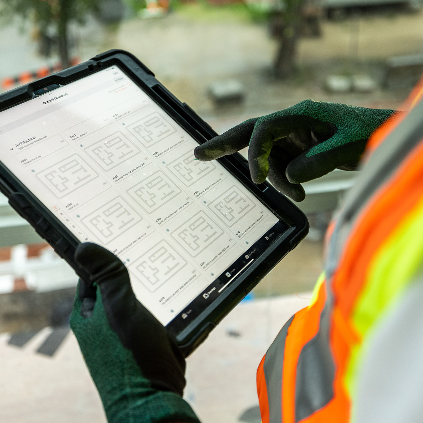 worker using an tablet with PPT gloves at a jobsite