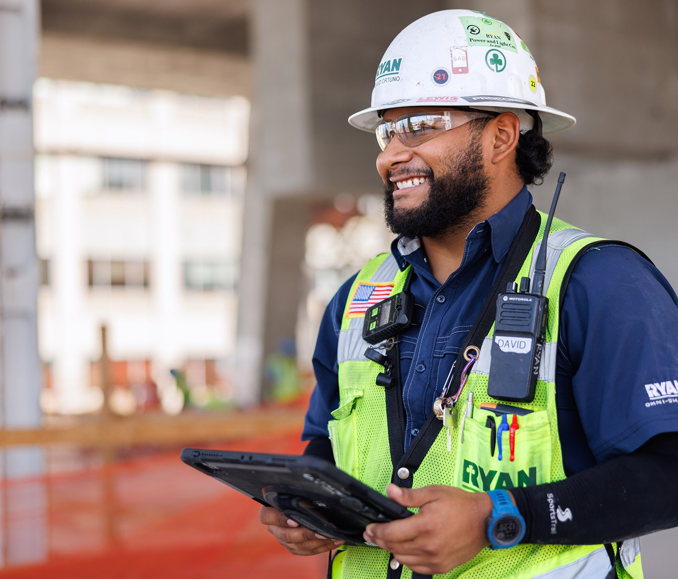 A construction worker holding a tablet on site