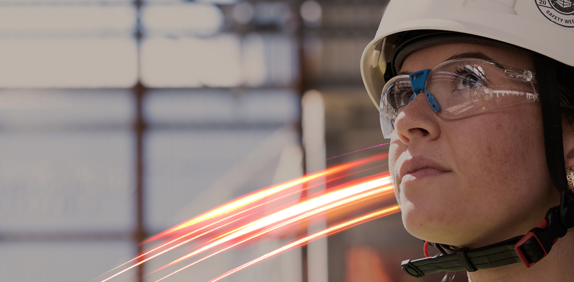 Woman wearing safety helmet and glasses with light streaks in background