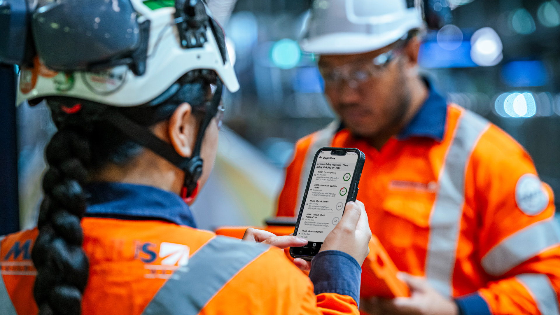 Two Martinus contractors using Procore on a smartphone