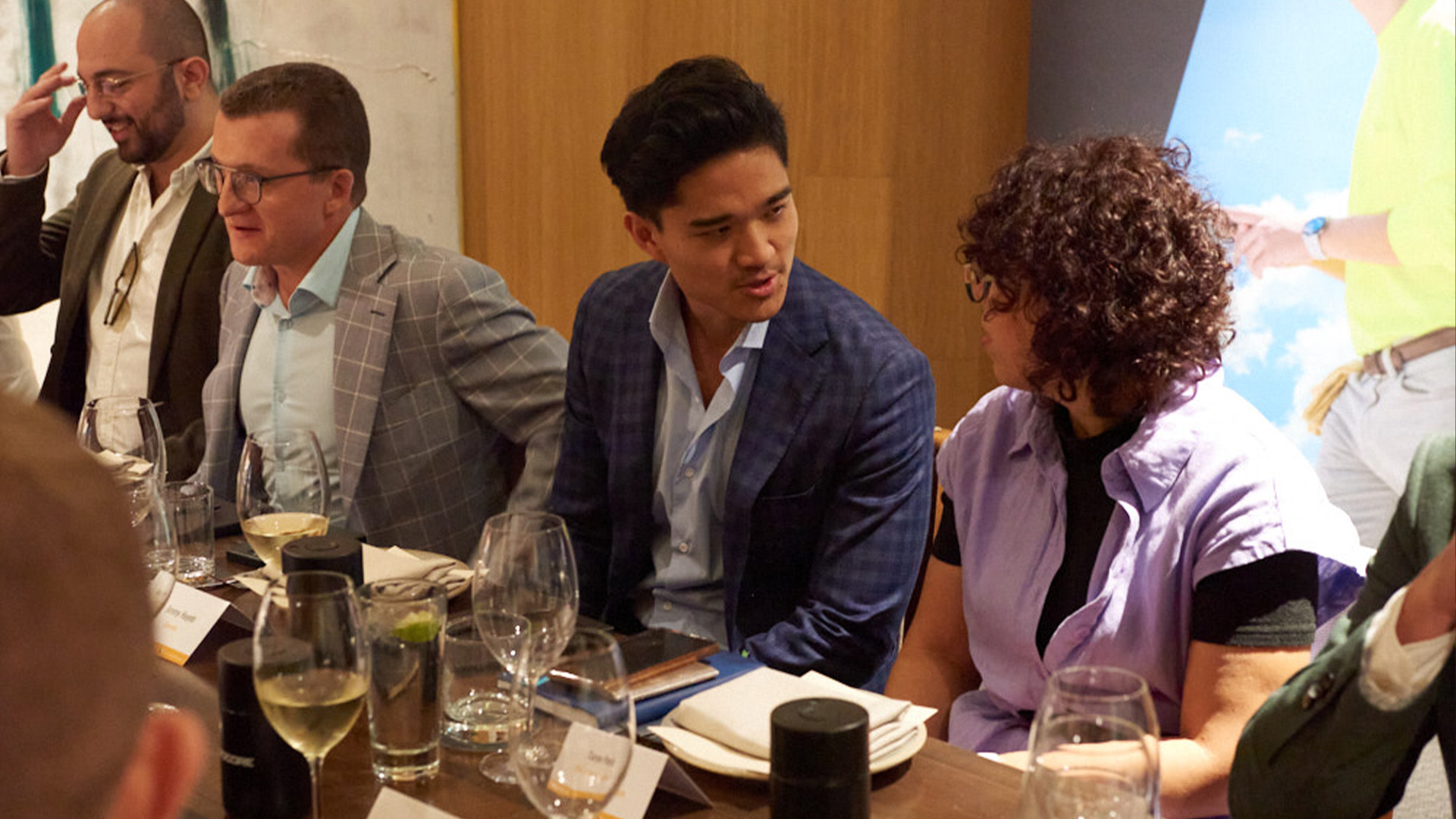 A group of people sitting at a table having a conversation