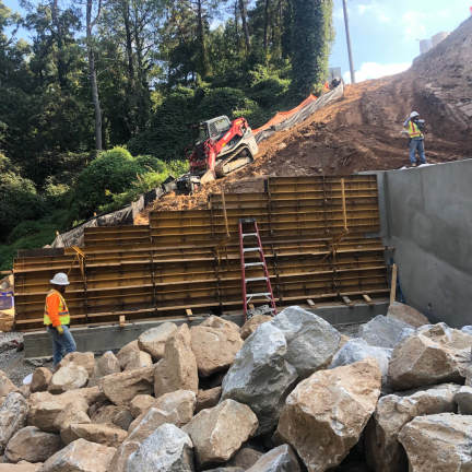 Construction workers setting up a barrier on a hill