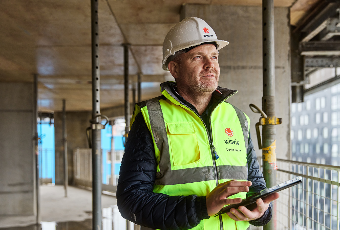 A construction worker using a tablet at a construction site