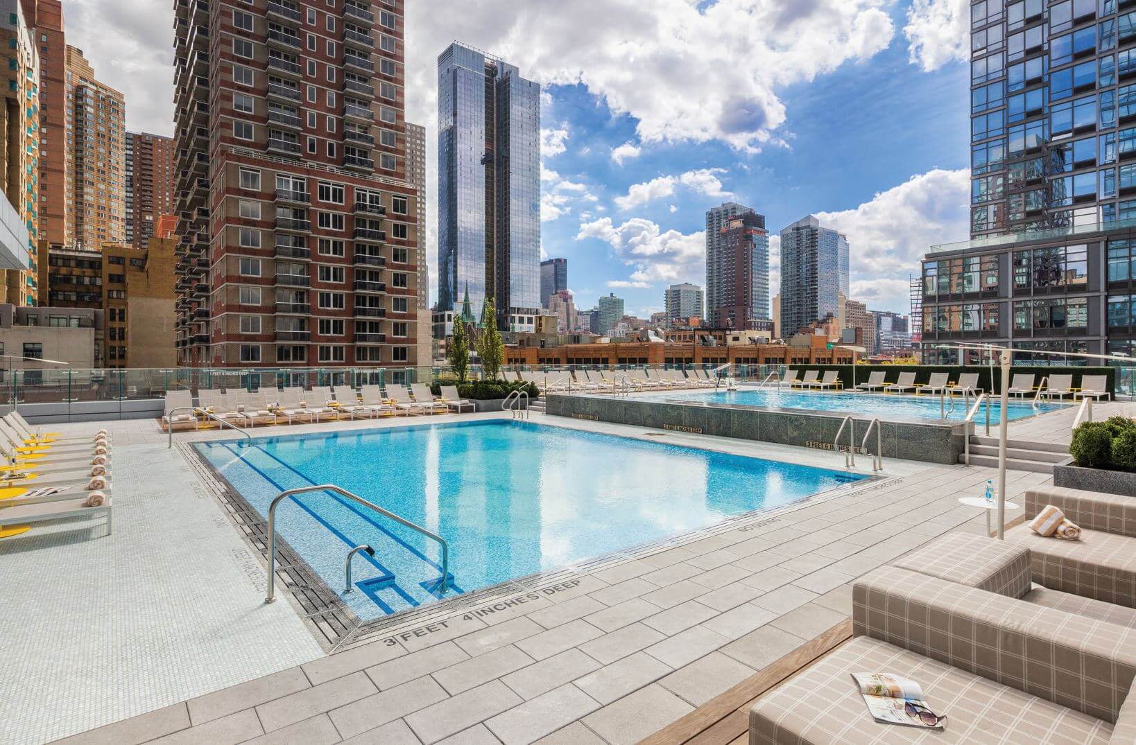 A view of a rooftop pool with skyscrapers surrounding it