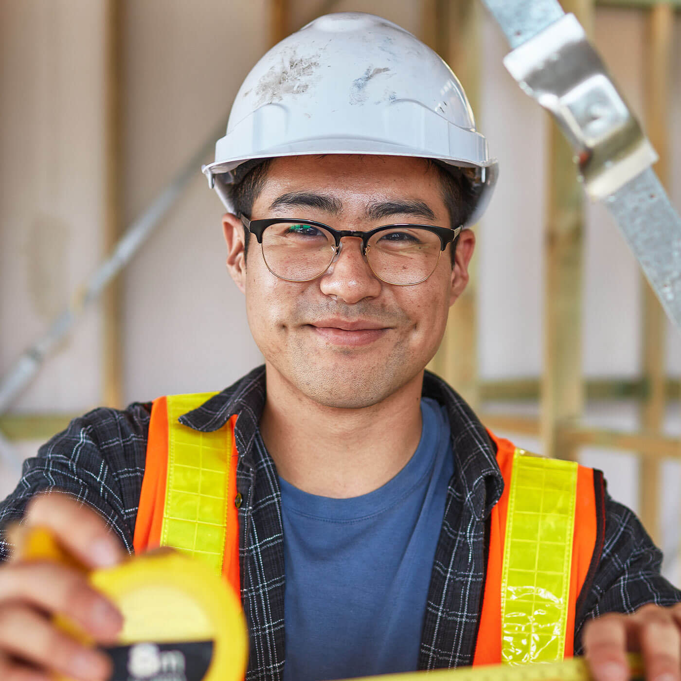Construction worker smiling into camera wearing PPE