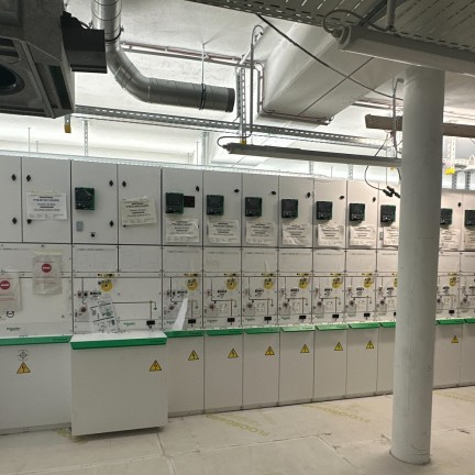 An electrical room with white cabinets