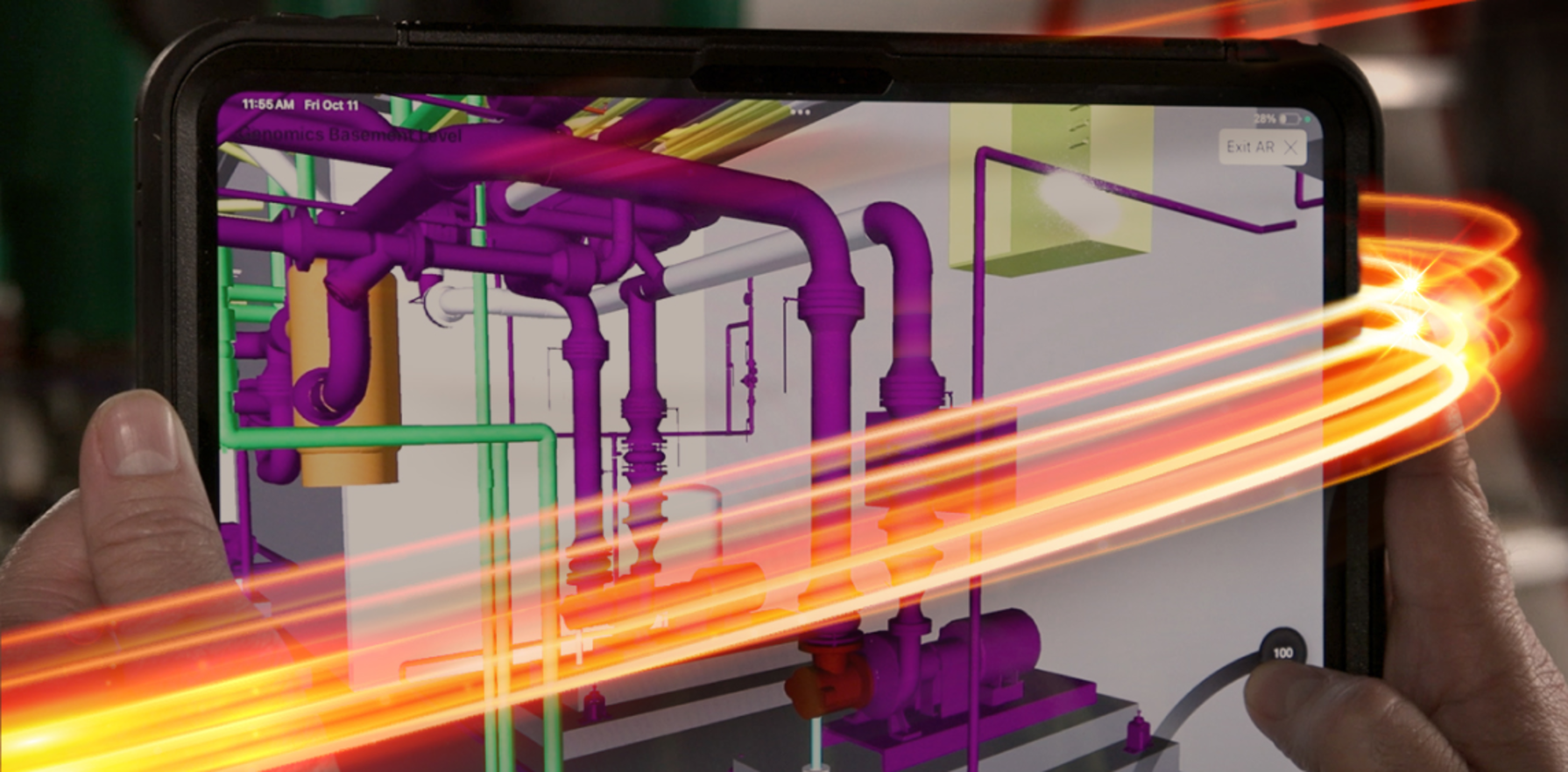 Hands holding a tablet displaying a 3D model of purple and green pipes.