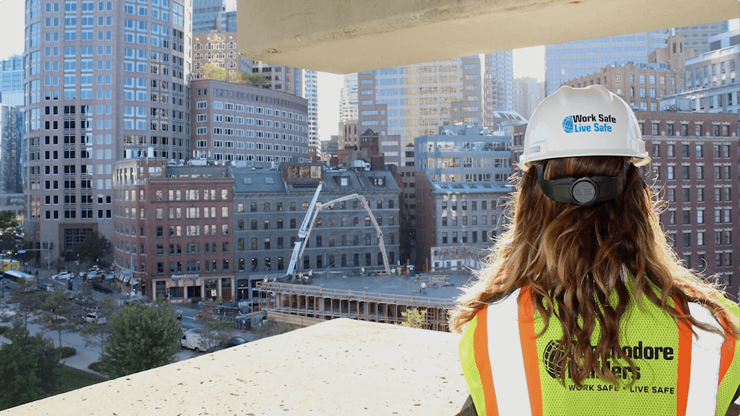 A woman contractor standing on a rooftop of a construction site