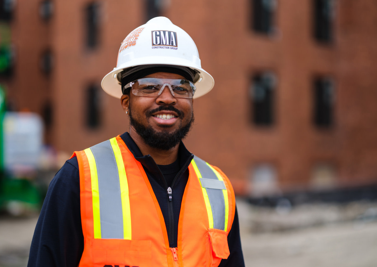 A man wearing safety gear smiling to the camera