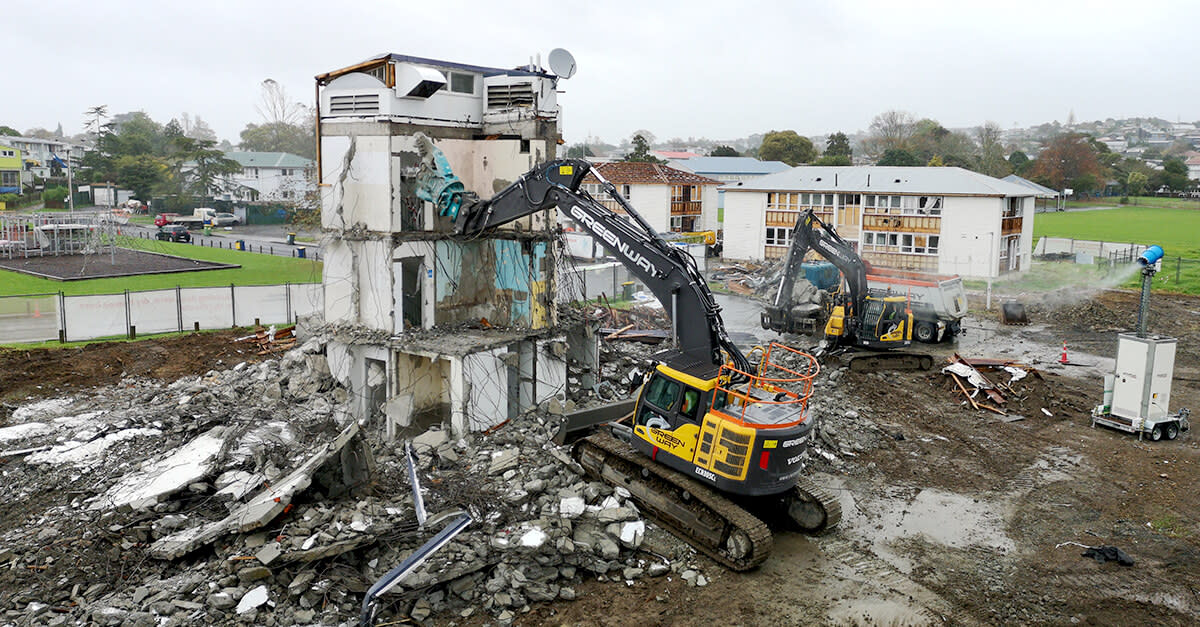 Large machinery tearing down an older building