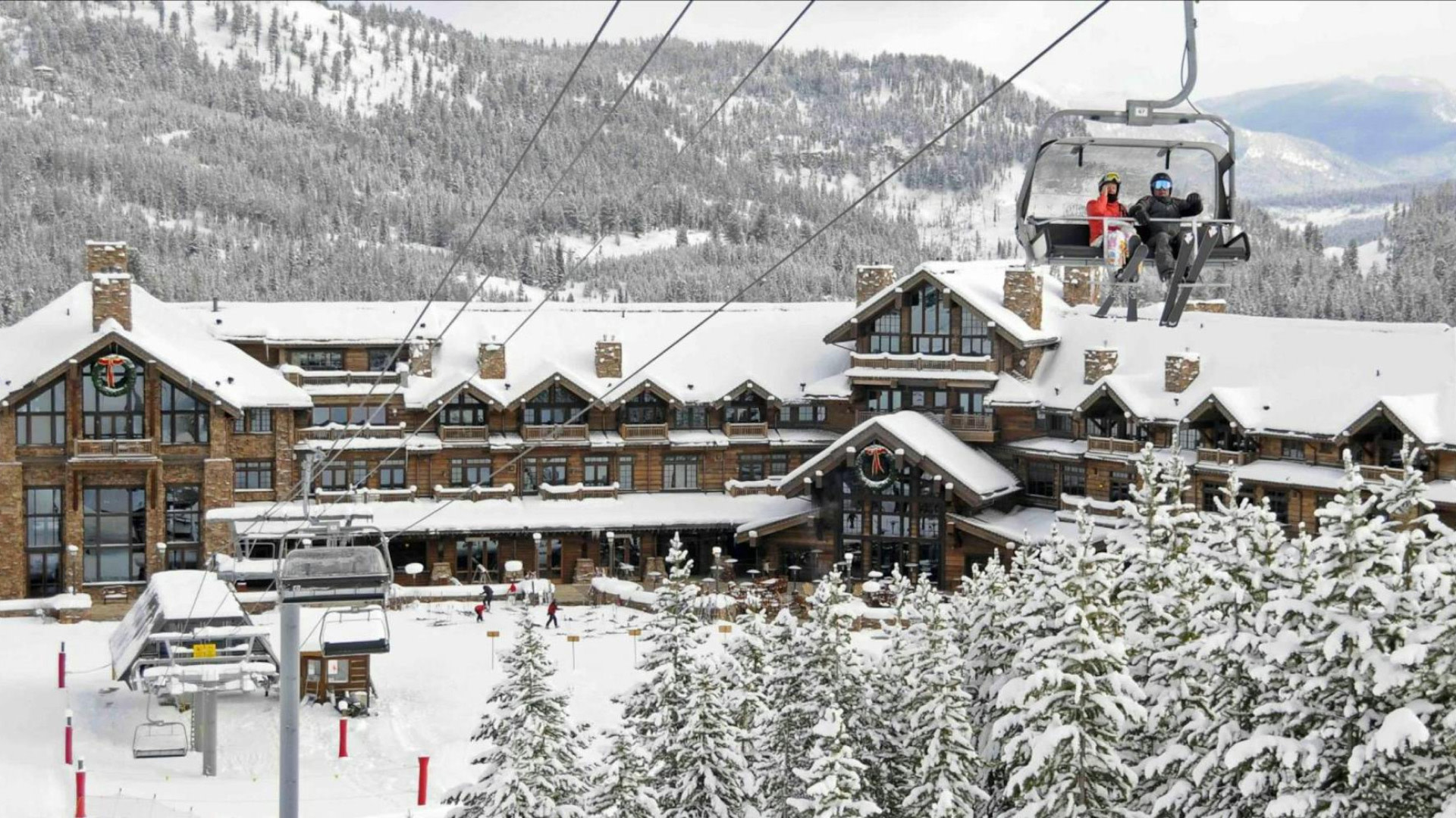 A snowy lodge's ski lift in the middle of the mountains