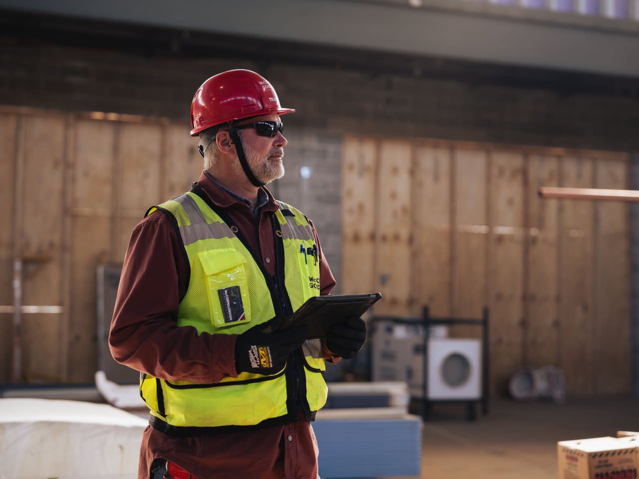 A man standing at a construction site holding a tablet