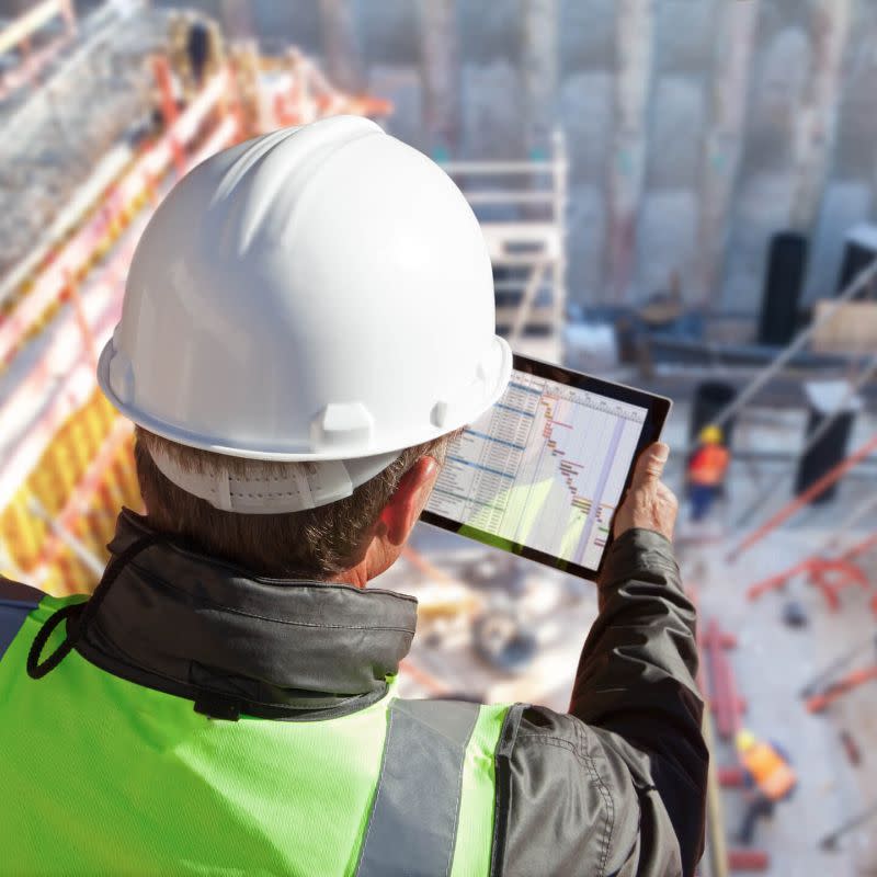 Construction worker looking at iPad on jobsite
