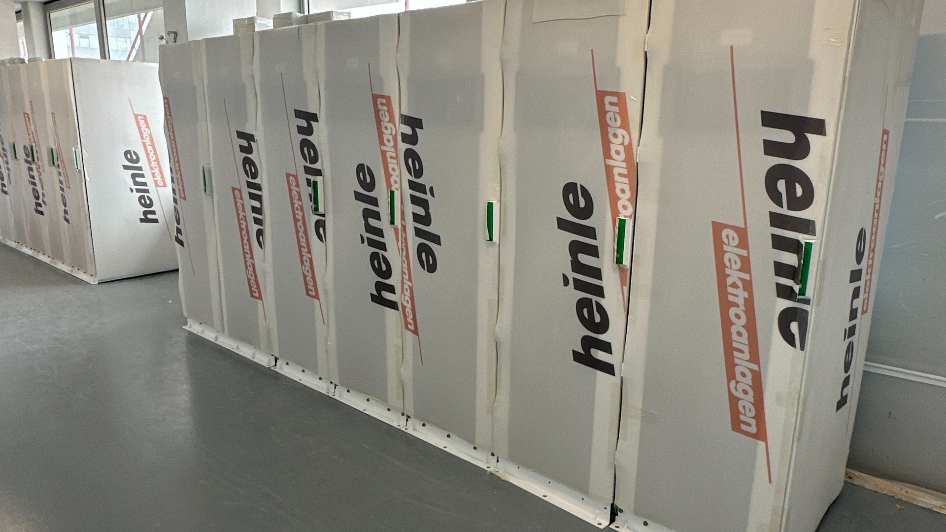 A row of white panels with Heinle's logo on them