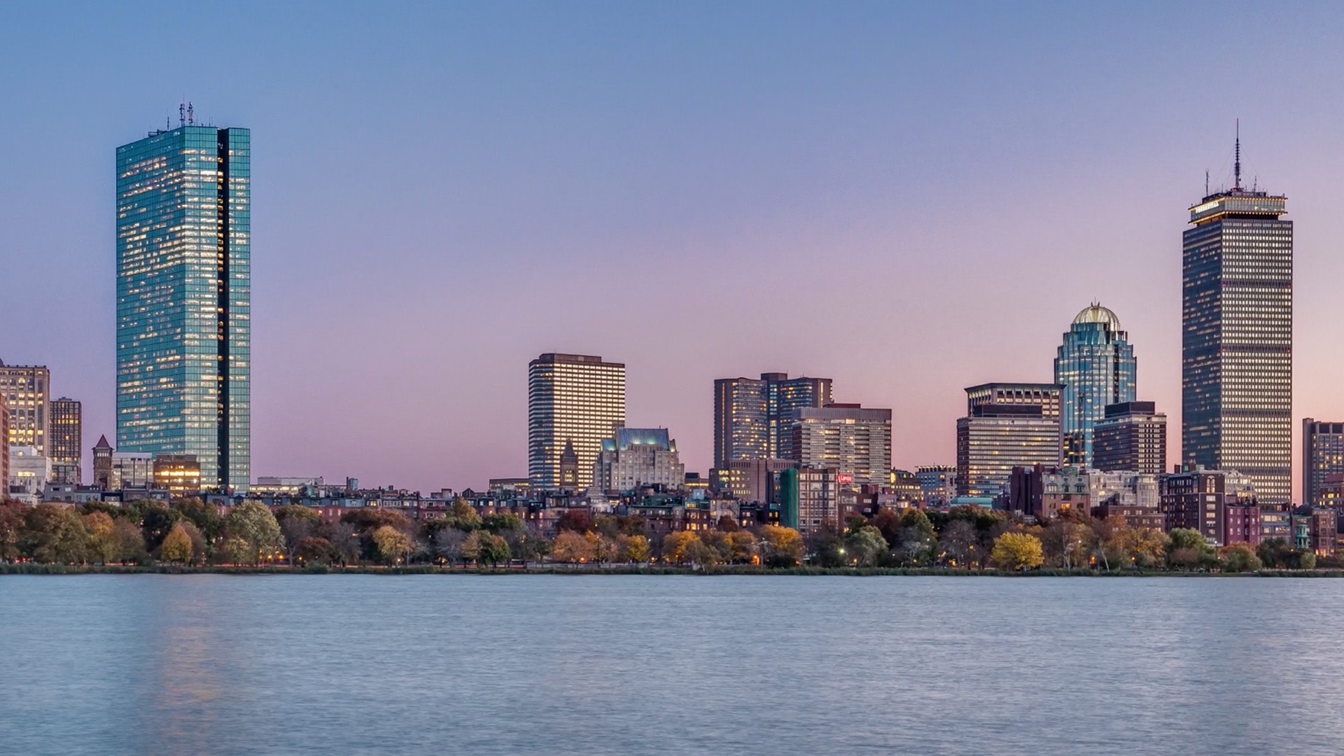 A city skyline with trees and water