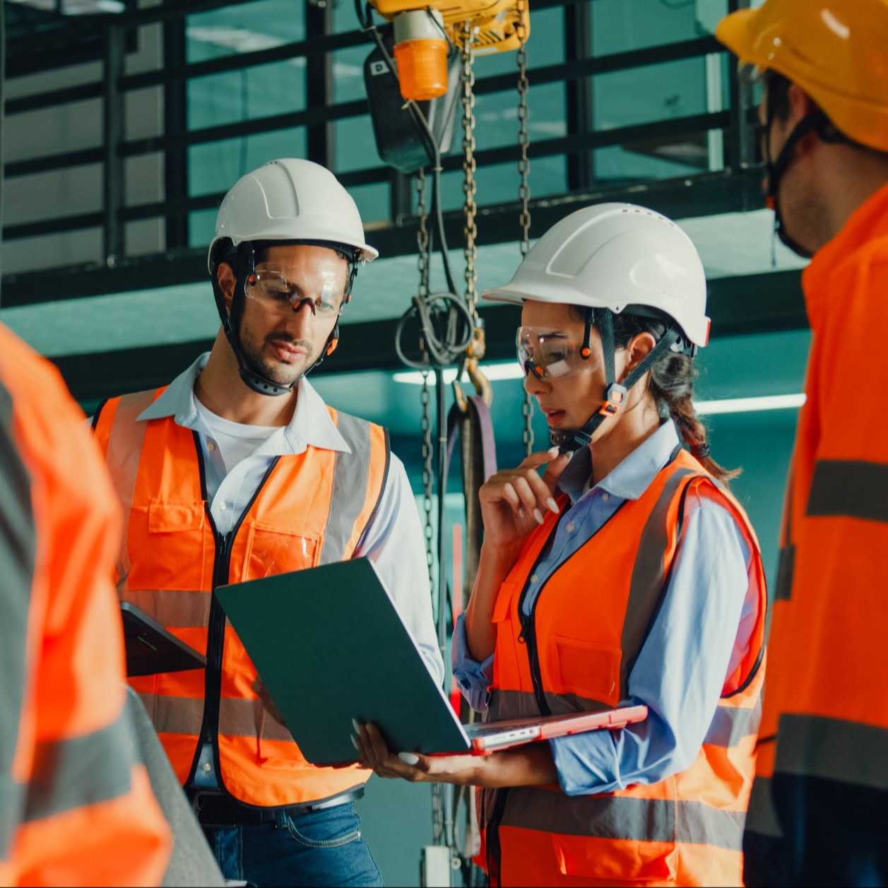 Two construction workers using a laptop on site