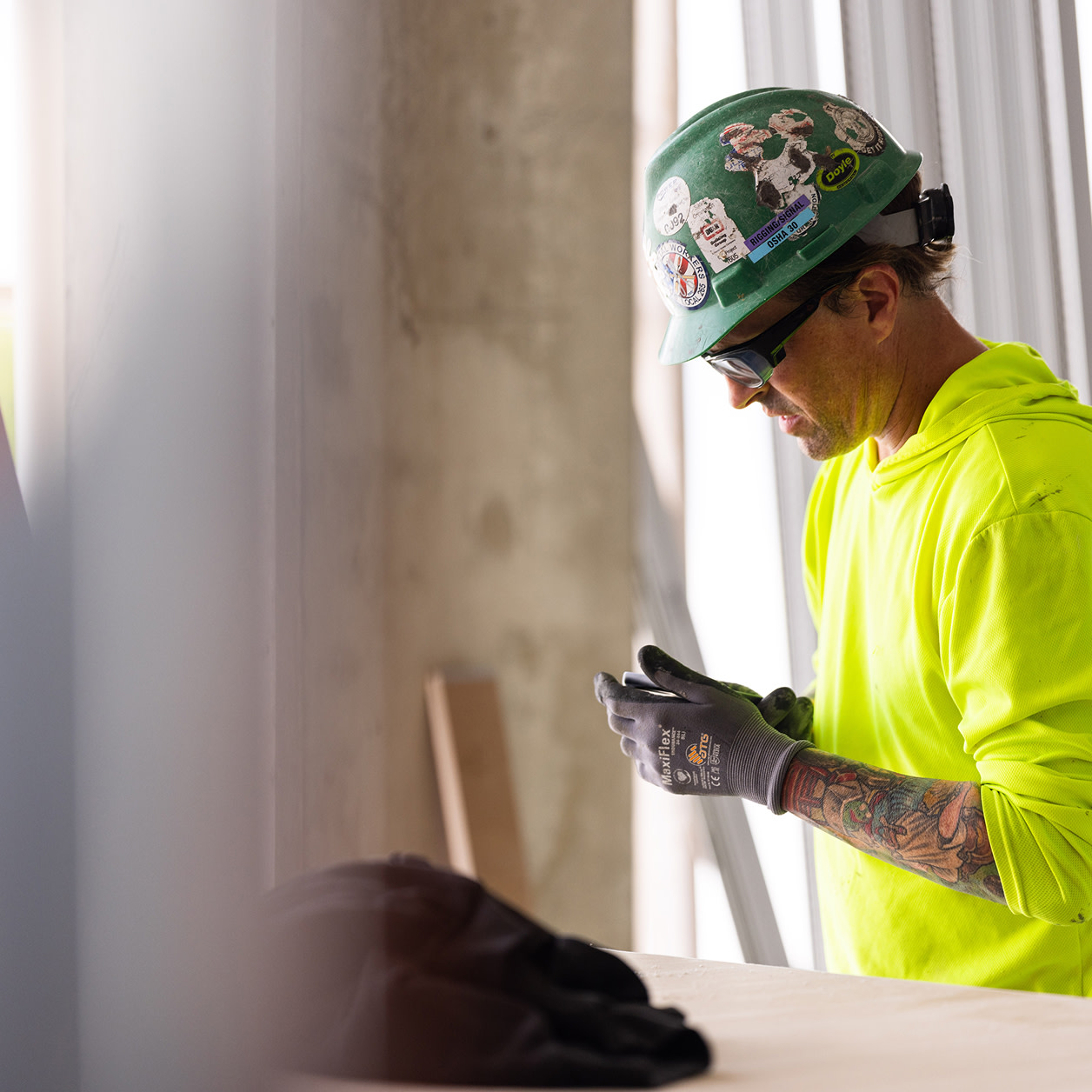 A construction worker fixing his gloves