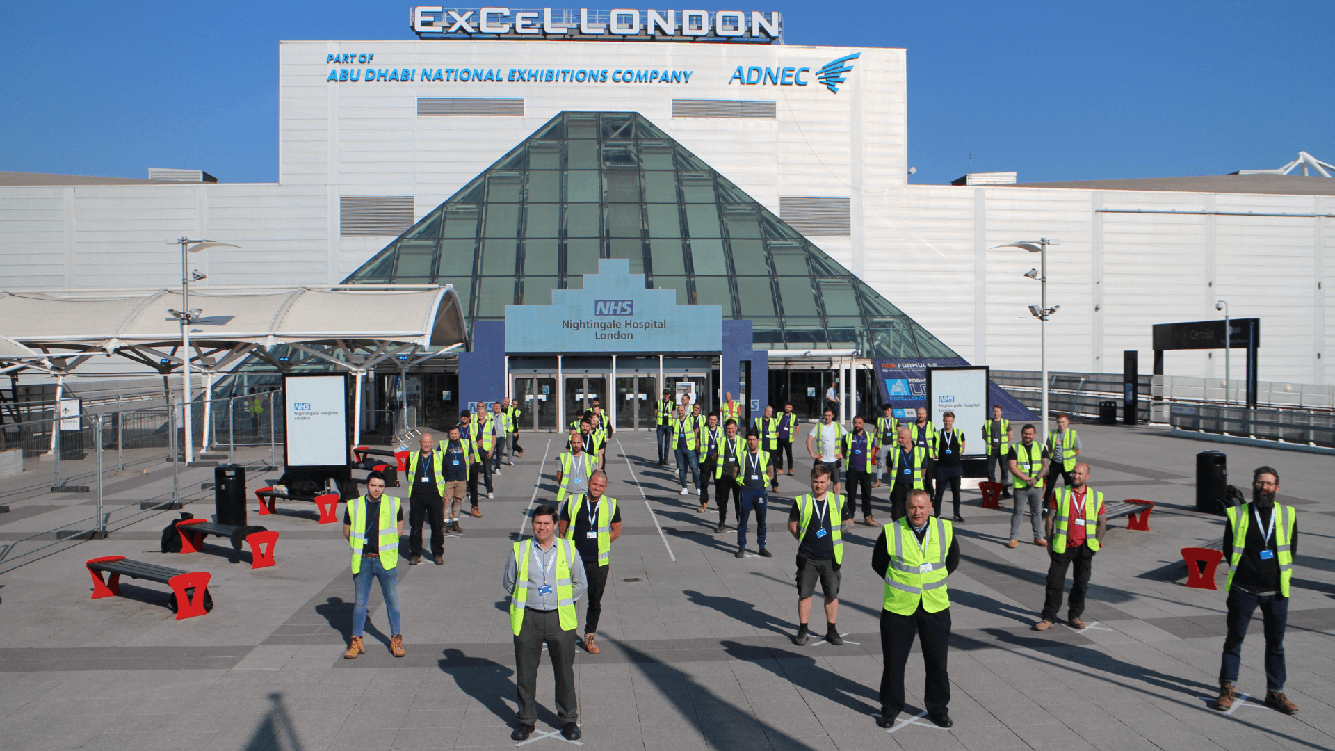 A group of people in reflective vests outside a building