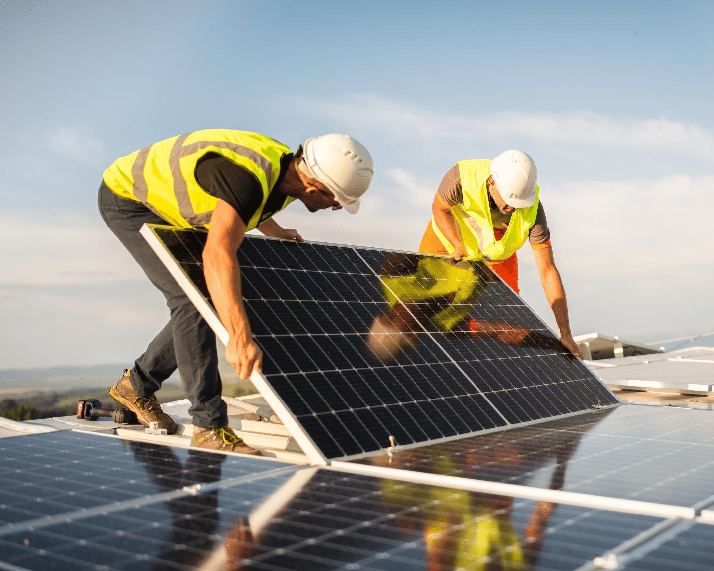 Two construction workers installing a solar panel