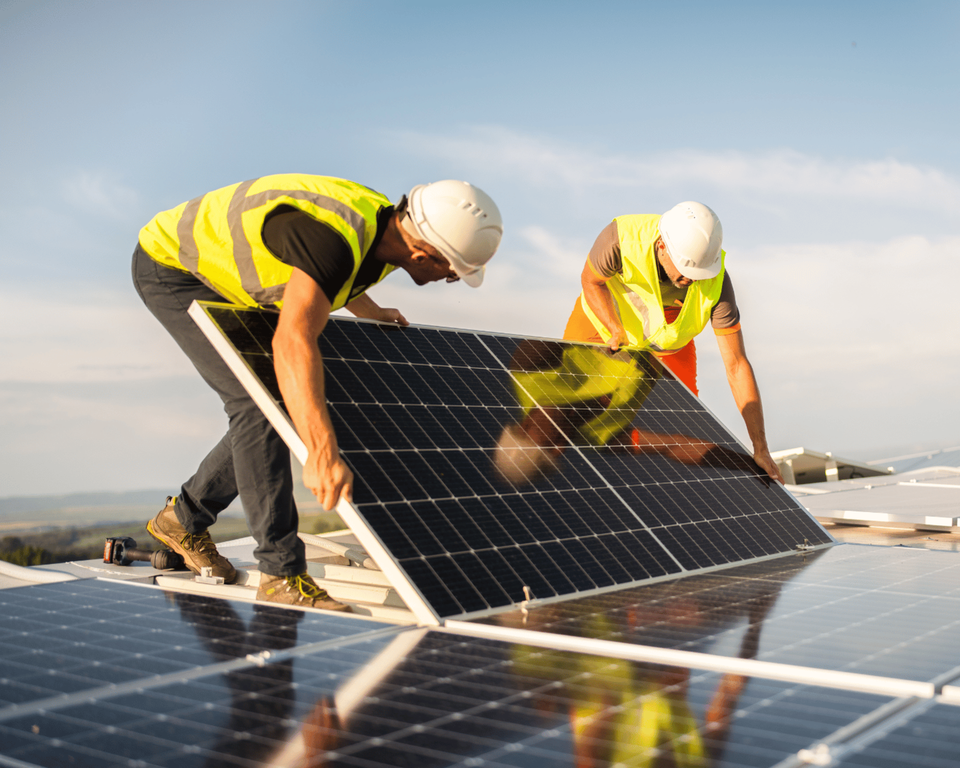 Two construction workers installing a solar panel