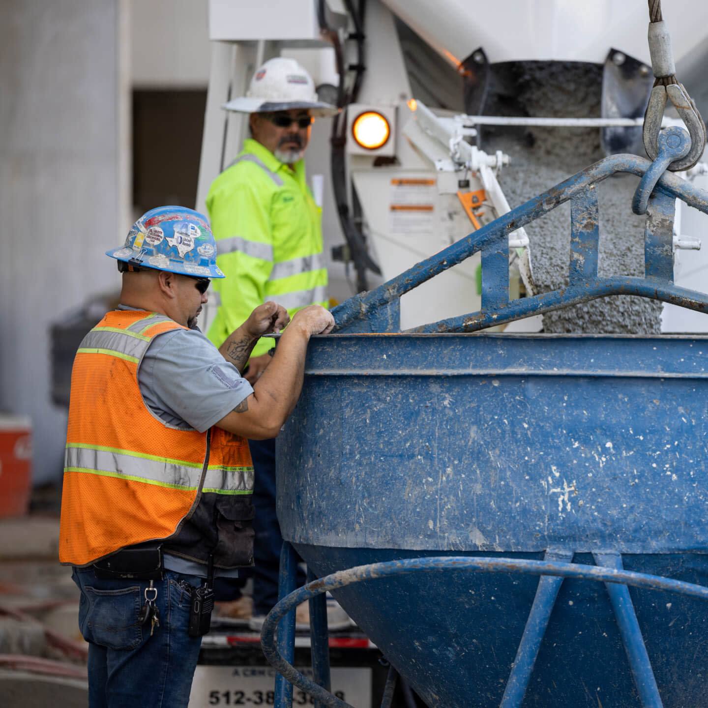 Two construction workers using a cement mixer