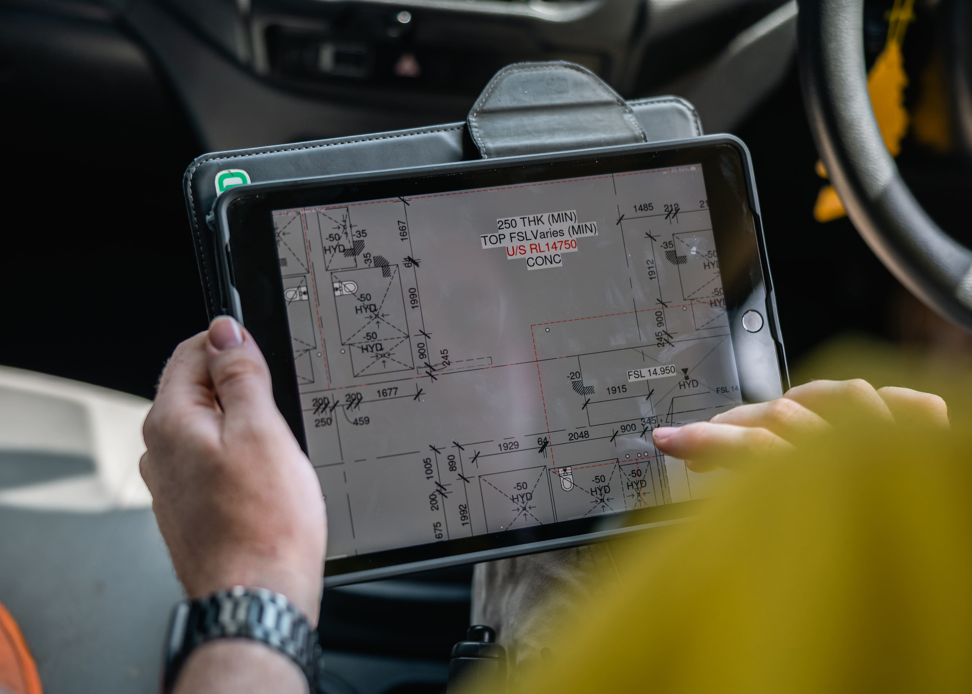 A contractor using Procore on a tablet