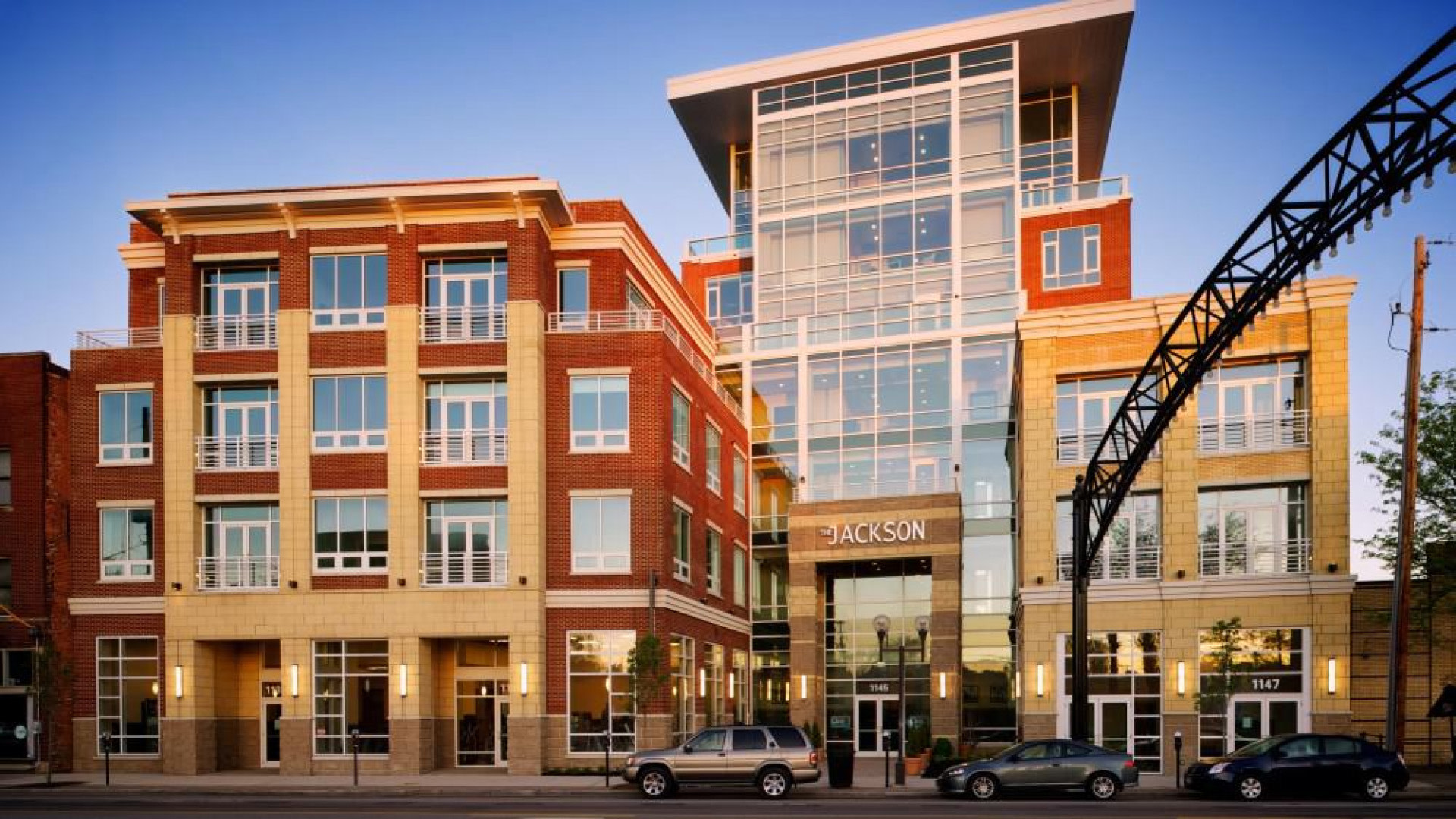 Two three stories building with cars parked on the street