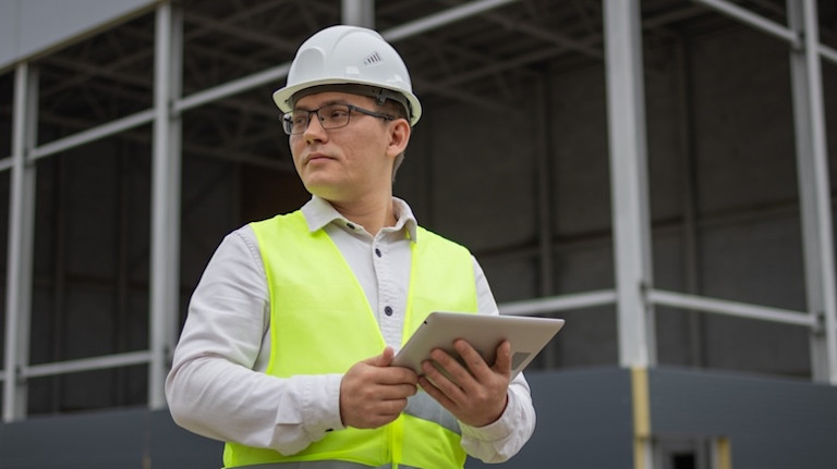 Project Manager holding a tablet on a commercial jobsite