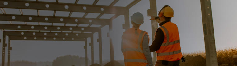 Contractors having a conversation while pointing to an area of a construction site