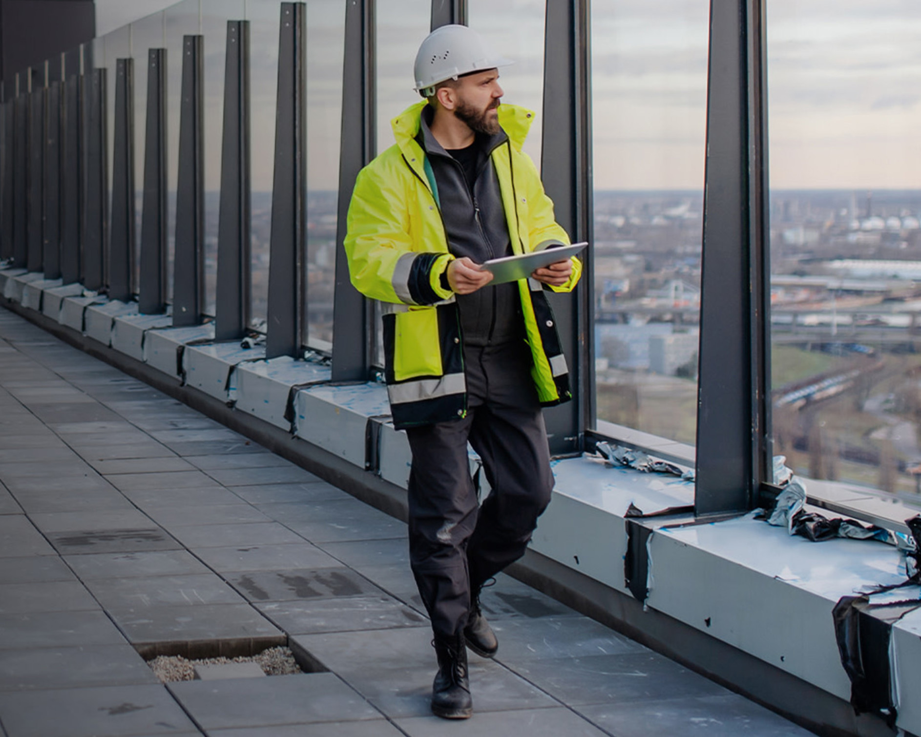 Contractor walking on a roof while holding a tablet