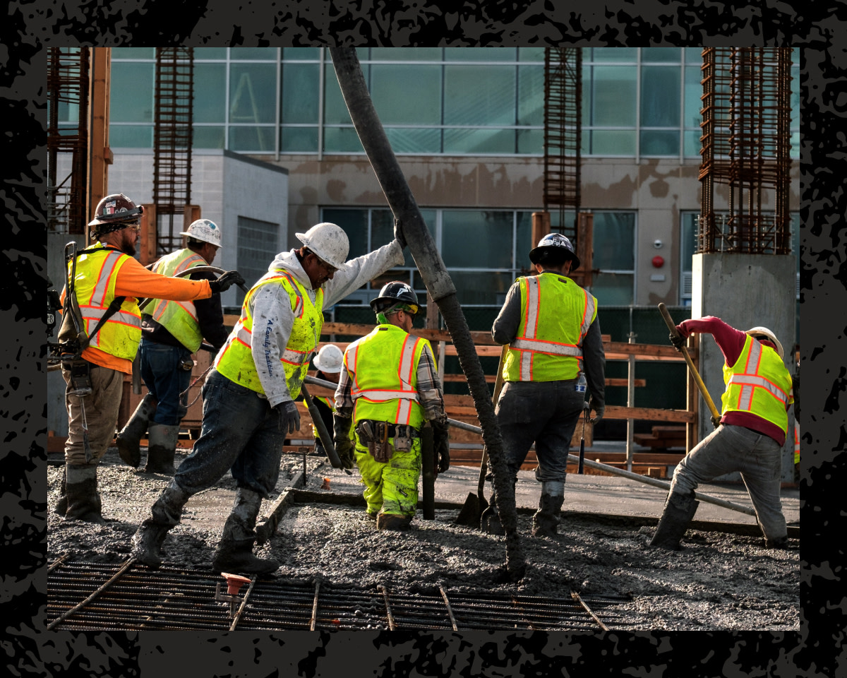 Construction workers standing up beams