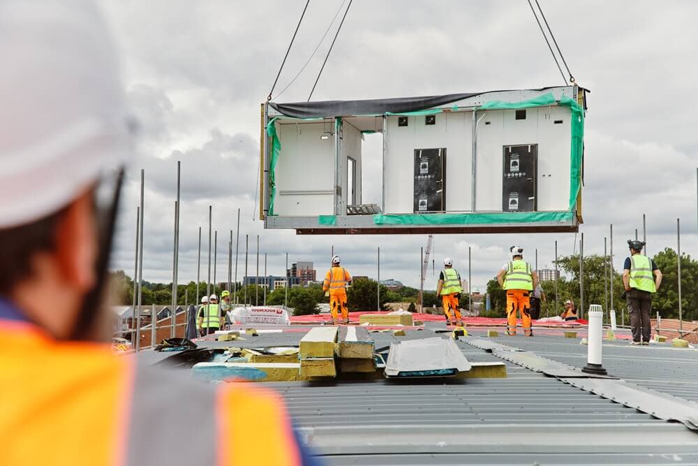 Construction workers standing up beams