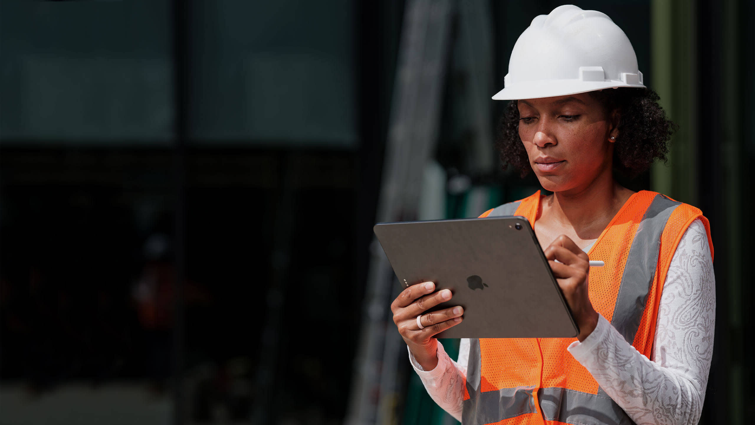 Un collaborateur du secteur de la construction tenant un appareil mobile sur le chantier.