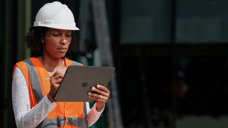 Construction worker holding a mobile device in the field
