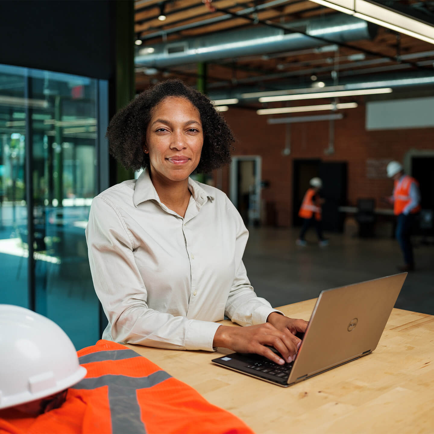 Woman working on her computer while looking at the camera