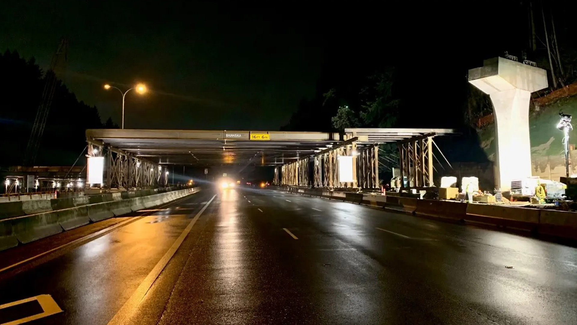 a road with a bridge over it at night time