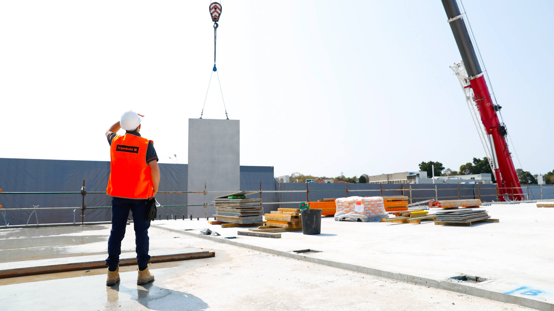 Prime Build general contractor on top of a roof directing a machinery