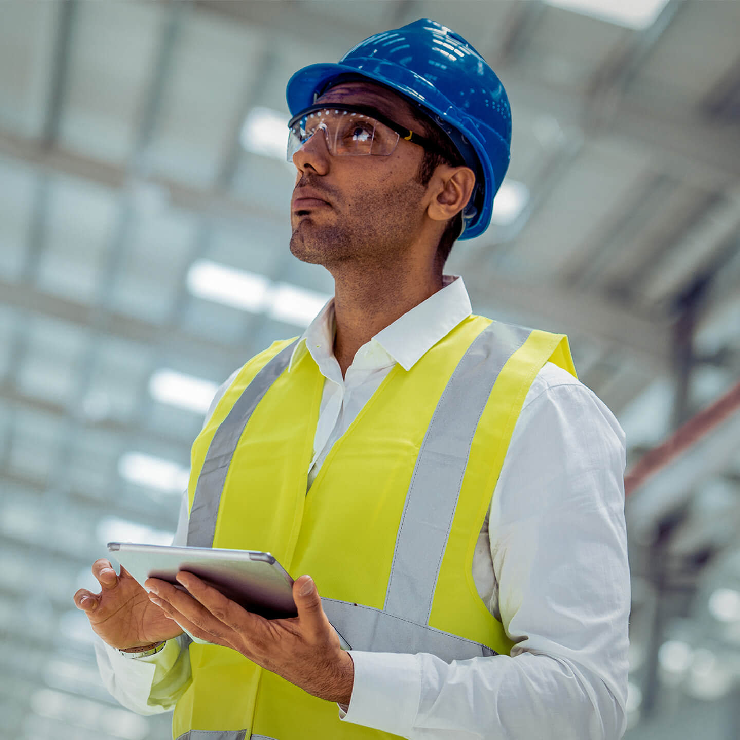 Contractor looking up while holding a tablet