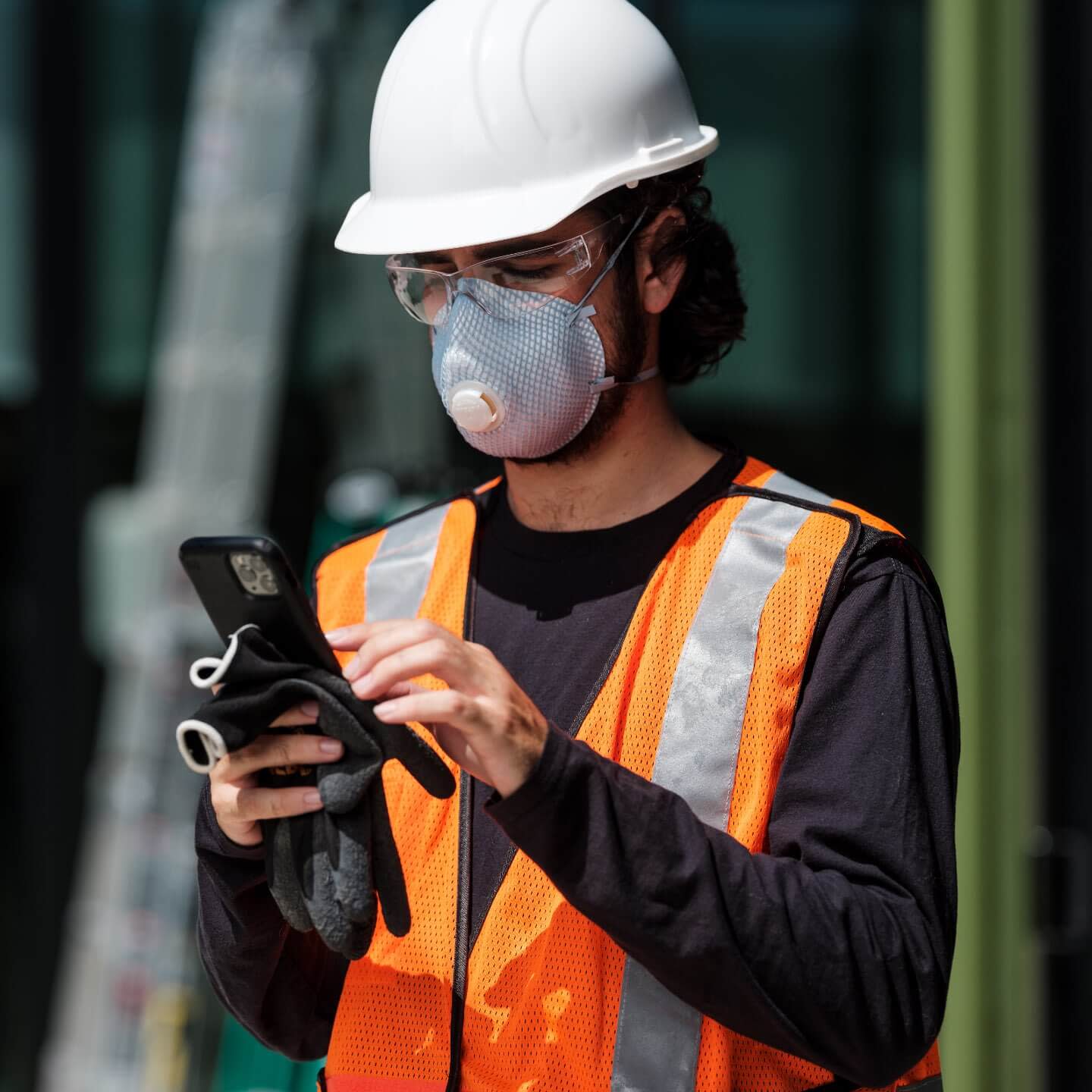 Worker with PPE using a mobile device